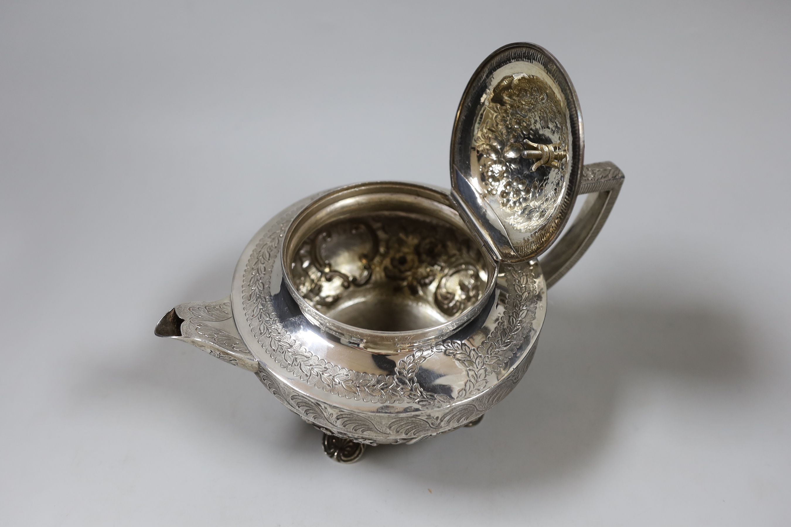 A George III engraved silver squat circular teapot, with foliate decoration and rose finial, by John Emes, London, 1803, gross weight 24.8oz. (See lot 868 for a near matching cream and sugar bowl). Ivory submission refer